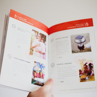 Person displaying a printed spread of the 2016 catalog.