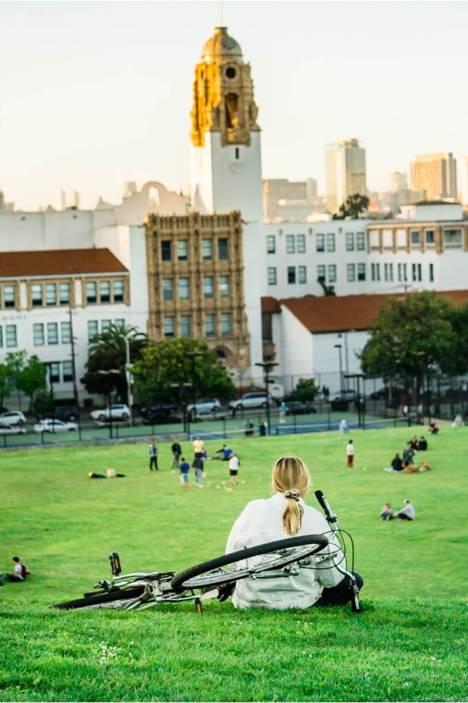 Girl on a field overlooking a city.